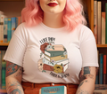 Woman wearing white t-shirt with stack of books and flowers graphic and text 'I Like Them Thick & Spicy'