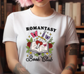 White t-shirt featuring a colorful Romantasy Book Club design with an open book, sword, butterflies, and roses
